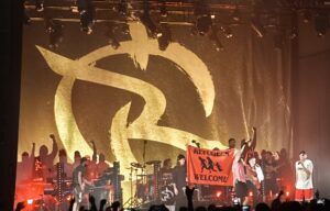 Irie Révoltés live im Schlachthof Wiesbaden, Foto von der Bühne, die Band hält ein 'Refugees Welcome'-Banner hoch.