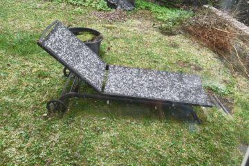 Gartenliege auf Wiese, dünn mit Schnee bedeckt