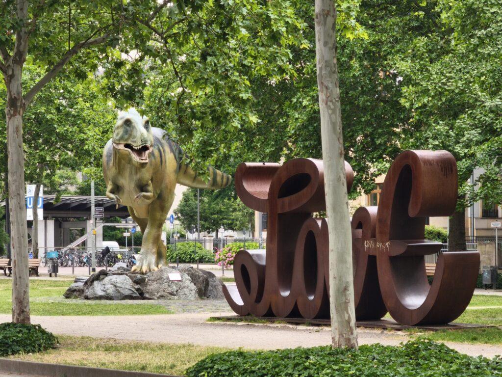 Senckenberg-Allee mit dem großen Tyrannosaurus Rex und dem Metall-Schriftzug Love im Trennstreifen zwischen den Fahrtsrichtungsspuren
