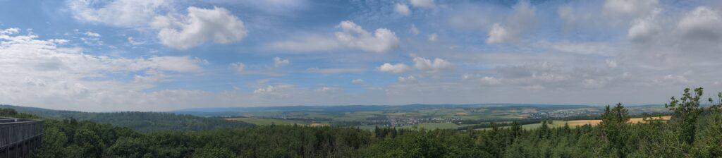 Panoramaaufnahme vom Hintertaunus mit Bäumen, Wiesen, Feldern, Ortschaften und Himmel